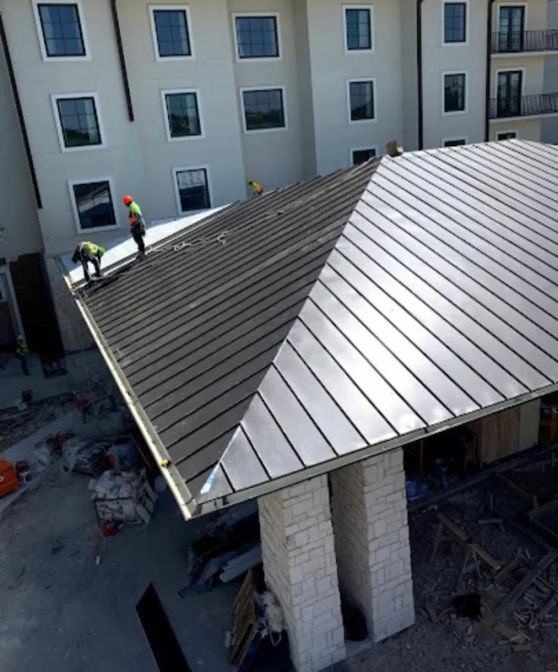 Crew installing standing seam metal roof panels on a commercial project in Burlingame
